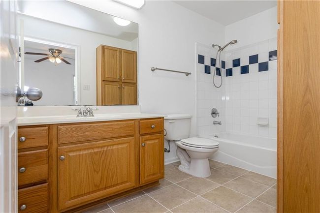 Bathroom with vanity, tile patterned flooring, bathtub / shower combination, and ceiling fan | Image 12