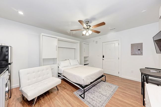 Bedroom featuring electric panel, light wood finished floors, a ceiling fan, and recessed lighting | Image 9