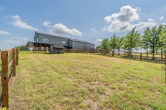 View of yard featuring an outbuilding, an outdoor structure, an exterior structure, and a rural view | Image 13