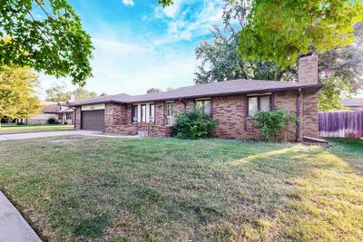 Ranch-style house with a front yard and a garage | Image 2