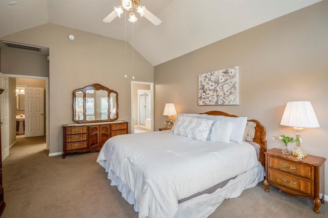 From near the bay windows in the primary bedroom, looking back you can see the half bath under the stairs through the doorway on the left. To the right, another doorway offers a glimpse into the primary bath, adding to the home's thoughtful design and layout. | Image 18