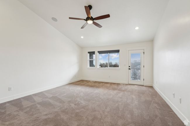 Empty room with carpet, baseboards, recessed lighting, ceiling fan, and vaulted ceiling | Image 24
