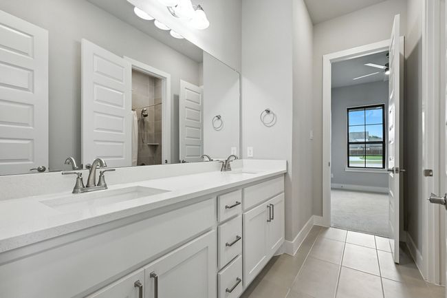 Full bathroom with double vanity, tiled shower, and tile patterned flooring | Image 24