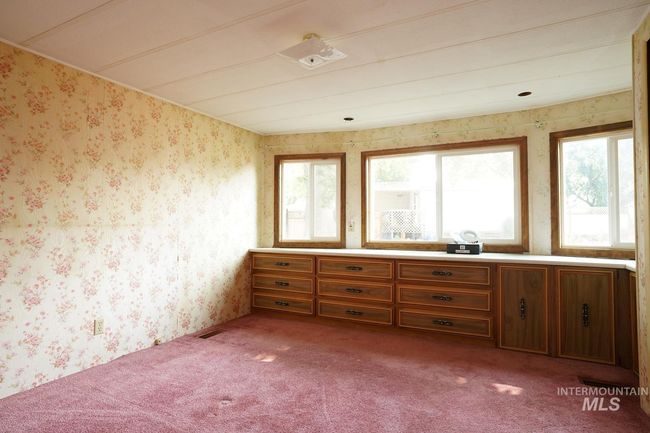 Spare room featuring carpet and wallpapered walls | Image 4