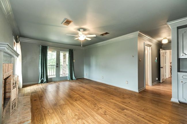 The spacious primary suite features a cozy fireplace and a set of French doors that opens to the balcony. | Image 22