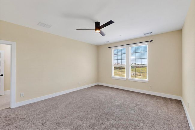 Carpeted empty room with a ceiling fan and baseboards | Image 8