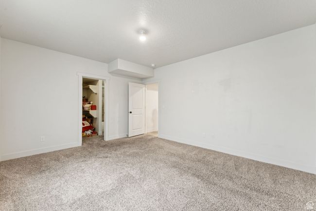 Unfurnished bedroom featuring carpet flooring, a spacious closet, baseboards, and a closet | Image 12