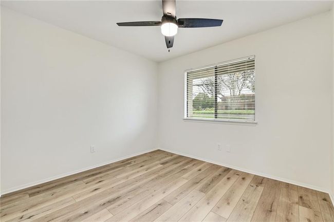 Unfurnished room with wood-type flooring, baseboards, and a ceiling fan | Image 8
