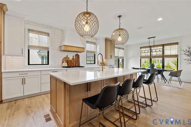 Kitchen with recessed lighting, light countertops, tasteful backsplash, light wood finished floors, and custom range hood | Image 19