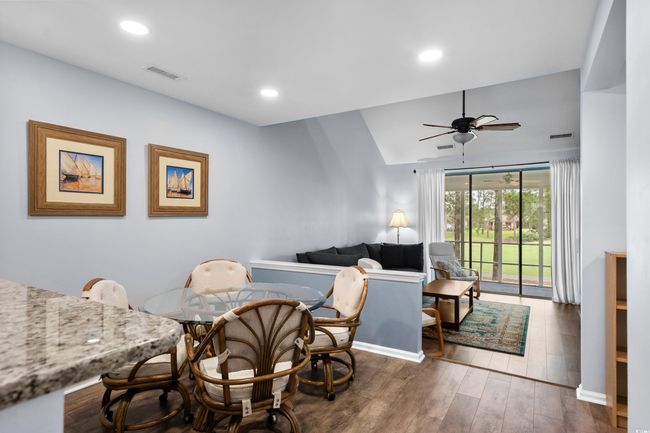 Dining area with a ceiling fan, dark wood finished floors, baseboards, vaulted ceiling, and recessed lighting | Image 11