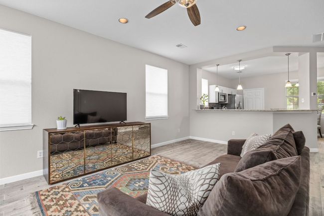 Living room with baseboards, wood finished floors, and ceiling fan | Image 10