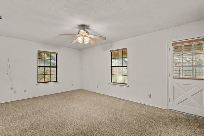 Master bedroom with visible vents, ceiling fan, carpet flooring, and a textured ceiling | Image 14