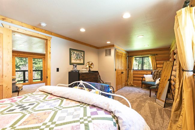 upstars bedroom featuring rustic walls, access to outside, recessed lighting, and french doors | Image 27