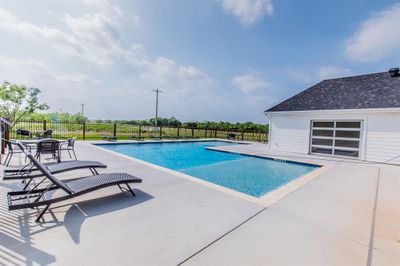 View of swimming pool with a patio | Image 3