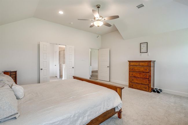 Bedroom featuring light colored carpet, a ceiling fan, baseboards, and high vaulted ceiling | Image 21