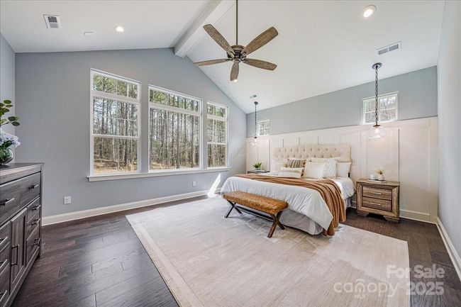 Primary Bedroom on the main level looking out at your private backyard while basking in ample natural light. The owner added custom window treatments for your enjoyment. | Image 17