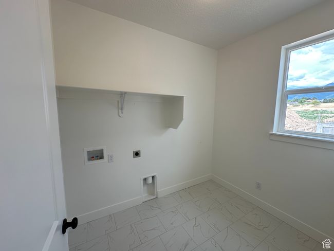 Laundry room with light marble finish flooring, electric dryer hookup, hookup for a washing machine, and a textured ceiling | Image 12