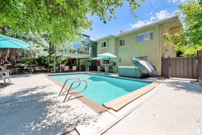 View of swimming pool with a patio and a gate | Image 22