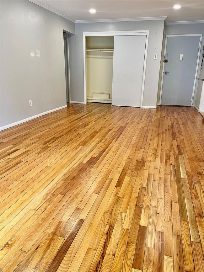 Unfurnished bedroom with recessed lighting, ornamental molding, baseboards, light wood-style flooring, and a closet | Image 9