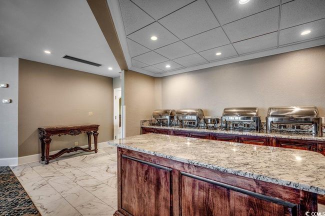 Kitchen with light stone countertops, a drop ceiling, and a kitchen island | Image 37