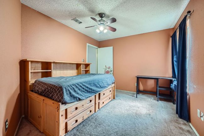 Bedroom featuring light carpet, a textured ceiling, and ceiling fan | Image 19