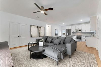 The living room's corner captures the essence of comfortable living, seamlessly connecting with the kitchen for effortless entertaining. (Virtual Staging May Be Present) | Image 3