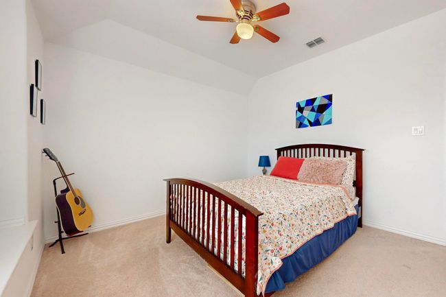 Bedroom featuring visible vents, baseboards, carpet flooring, and lofted ceiling | Image 32
