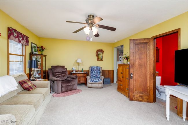 Carpeted living room featuring a ceiling fan | Image 12