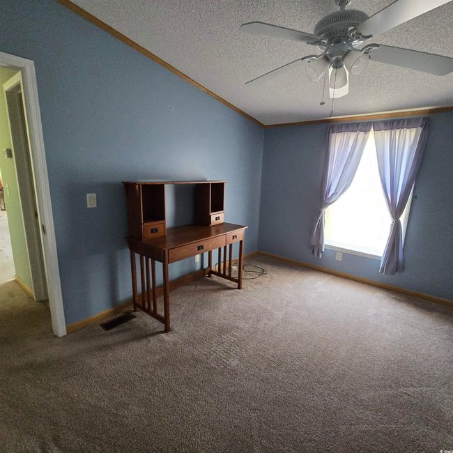 Unfurnished office featuring a textured ceiling, ceiling fan, carpet, and crown molding | Image 29