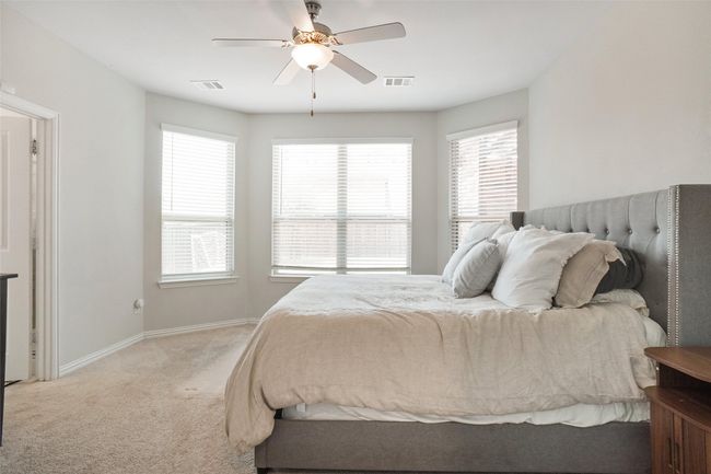 Bedroom with light carpet, multiple windows, baseboards, and a ceiling fan | Image 9