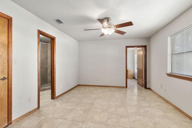 Unfurnished bedroom featuring baseboards, visible vents, ceiling fan, and connected bathroom | Image 31