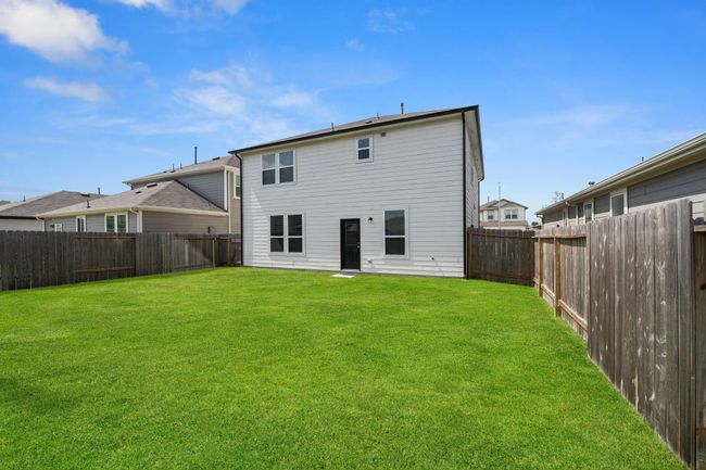 Cozy backyard features a low-maintenance concrete slab, ideal for a patio setup or utility use. A compact outdoor space perfect for simple living. | Image 30