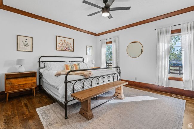 Bedroom with dark hardwood / wood-style flooring, crown molding, and ceiling fan | Image 18