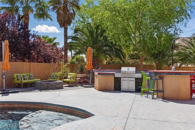 View of patio / terrace with outdoor dry bar, fence, a grill, and an outdoor fire pit | Image 42