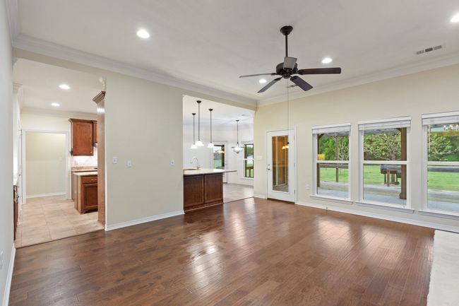 Unfurnished living room featuring ceiling fan, visible vents, recessed lighting, wood finished floors, and a sink | Image 4