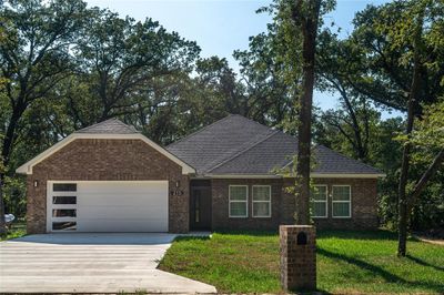 View of front of house featuring a garage and a front lawn | Image 1