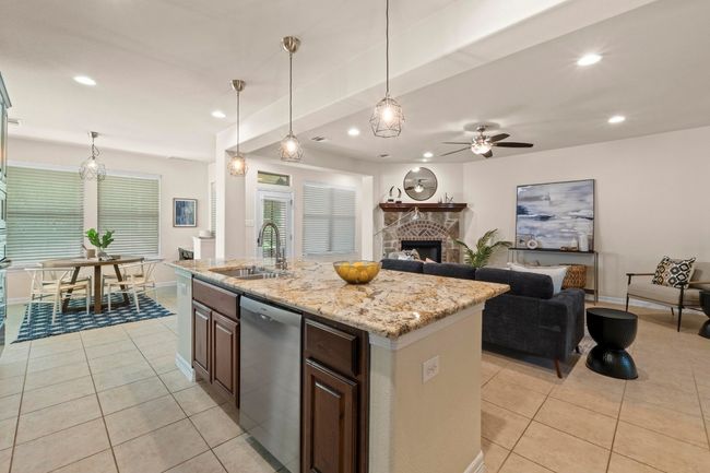 Kitchen featuring dishwasher, light tile patterned flooring, a stone fireplace, recessed lighting, and ceiling fan | Image 12