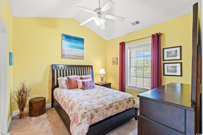 Carpeted bedroom featuring vaulted ceiling and ceiling fan | Image 10