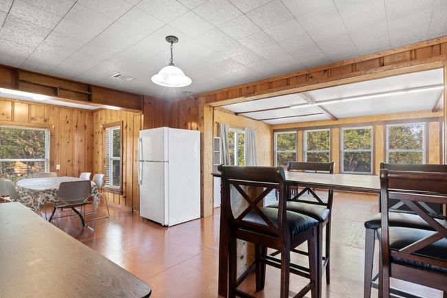 Kitchen with white fridge, decorative light fixtures, and wood walls | Image 12