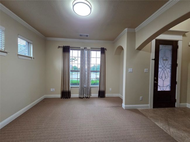 Entrance foyer featuring ornamental molding, arched walkways, and carpet | Image 35