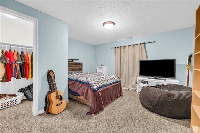 Bedroom featuring a textured ceiling, baseboards, and carpet floors | Image 17