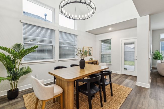 Dining area with a chandelier, dark wood-style flooring, and baseboards | Image 10