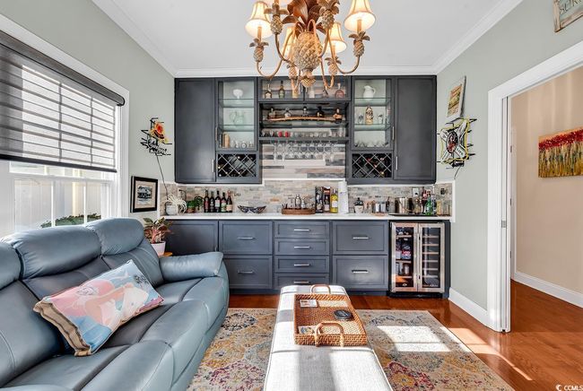 Living room with hardwood / wood-style flooring, ornamental molding, and an inviting chandelier | Image 6