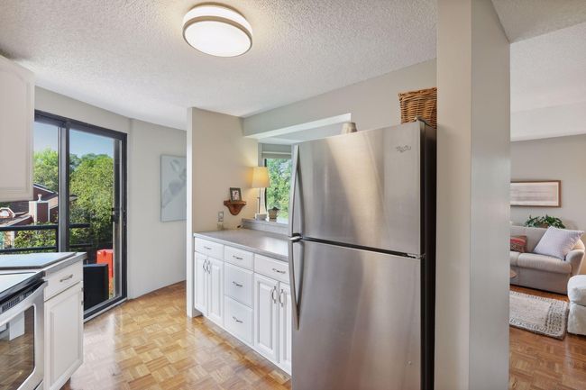 Thoughtfully updated kitchen with Corian countertops, stainless steel appliances, and newer cabinetry. | Image 10