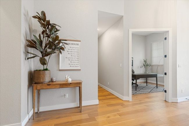 Hall with light wood-style floors, a desk, and baseboards | Image 4