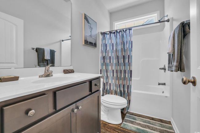 Full bathroom featuring wood finished floors, toilet, vanity, and shower / bath combination with curtain | Image 12