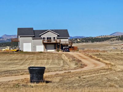 View of front of home with a deck with mountain view and a garage | Image 2