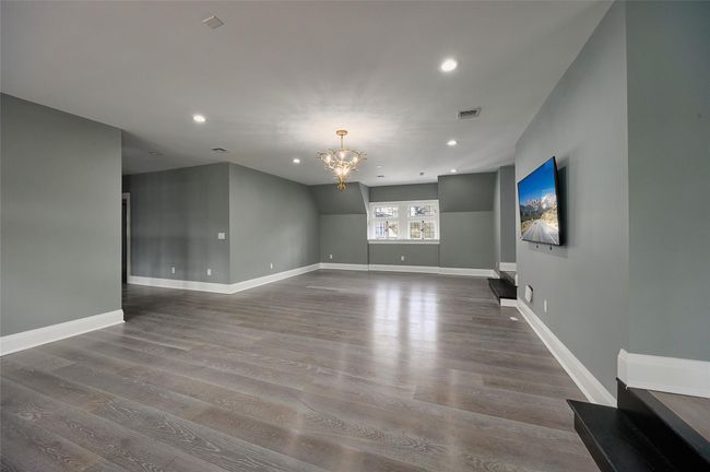 Unfurnished living room featuring recessed lighting, wood finished floors, a chandelier, baseboards, and visible vents | Image 15