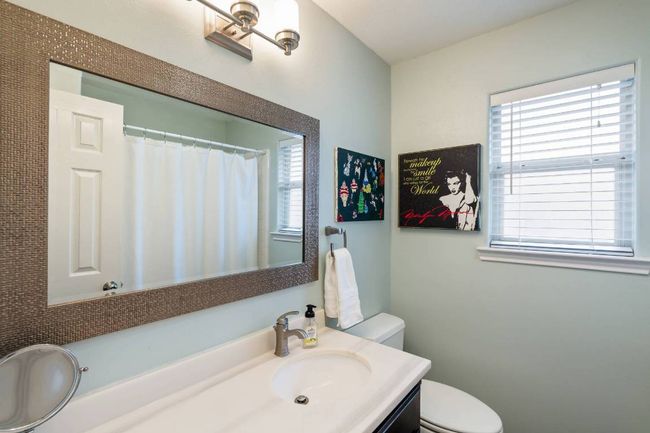 Full bathroom with toilet, a shower with curtain, and vanity | Image 15
