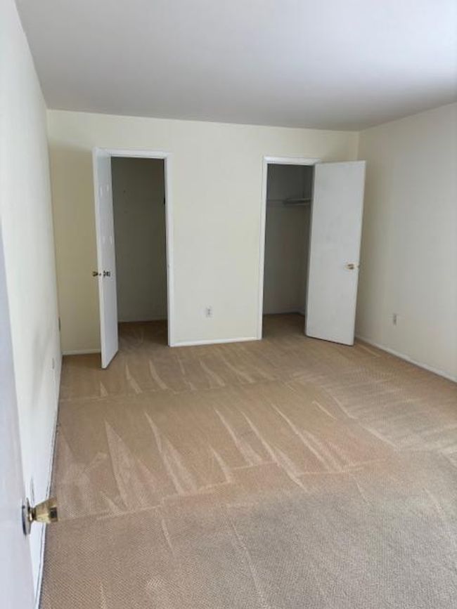 Large bedroom with carpeting and 2 walk-in closets | Image 9
